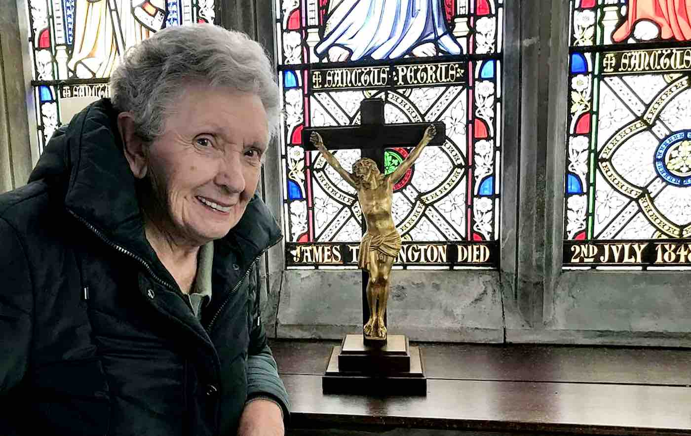 https://www.goodnewsnetwork.org/wp-content/uploads/2023/04/church-crucifix-with-older-woman-SWNS.jpg